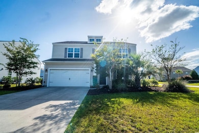 Traditional-style home with a garage, concrete driveway, and a front lawn