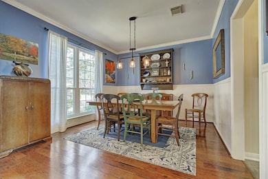 Formal dining room boasts chair rail molding, engineered floors and a 3 lantern farmhouse chandelier that  completes this charming room.