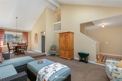 Peek-a-boo stairway landing overlooks living & dining rooms. Hardwood floors in entry & hallway visible