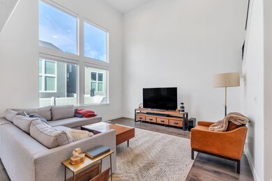 Living area featuring wood finished floors and a high ceiling