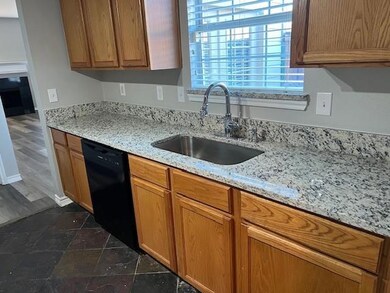 Kitchen featuring light stone counters, sink, and 