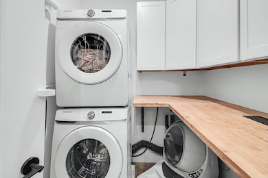 Washroom with stacked washer / dryer and cabinet space