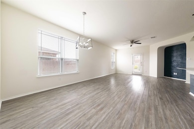 Empty room featuring arched walkways, baseboards,