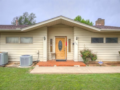 View of front of property with cooling unit, a front lawn, a chimney, and roof with shingles