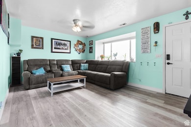 Living room featuring light wood-style floors and a ceiling fan