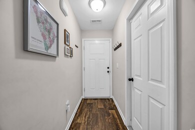 Entryway featuring baseboards, dark wood-style flo