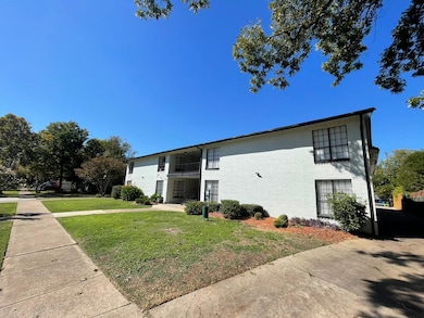 View of home's exterior featuring a balcony and a lawn