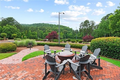 View of patio featuring an outdoor fire pit and a wooded view