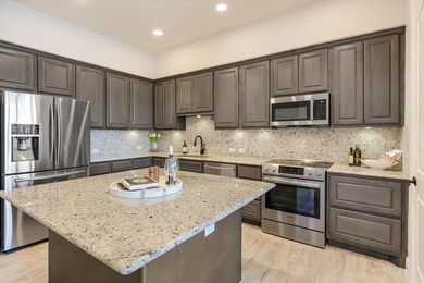 Kitchen featuring light stone counters, a sink, d