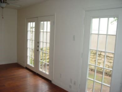 Doorway featuring wood finished floors, french doors, and a ceiling fan