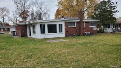 Back of property with a chimney and brick siding