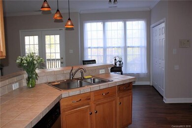 Kitchen view of stainless steel sink, tile counter