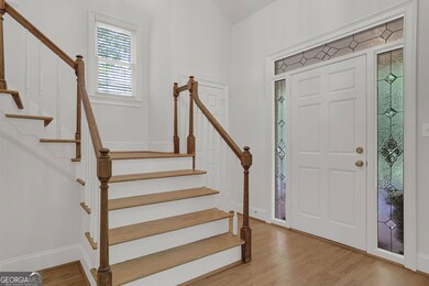 Light-filled 2 story foyer with site finished oak hardwood flooring.