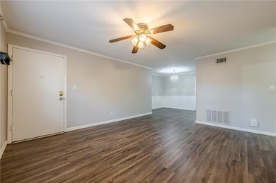 Unfurnished room featuring visible vents, dark woo