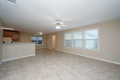 Unfurnished living room featuring ceiling fan and baseboards