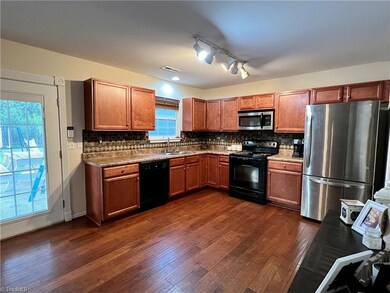 Open and bright kitchen accessing back covered patio area