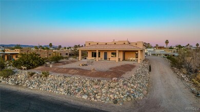 Southwest-style home featuring a tile roof, drivew
