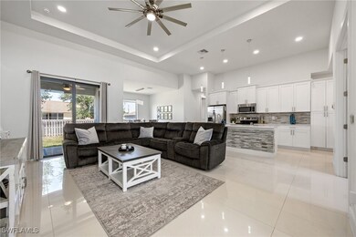 Living area with a ceiling fan, a tray ceiling, vi