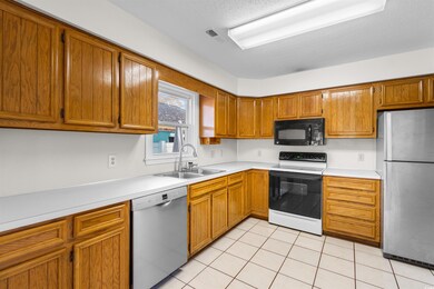 Kitchen featuring a textured ceiling, sink, light 
