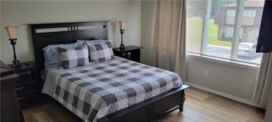 Bedroom featuring multiple windows and wood finished floors
