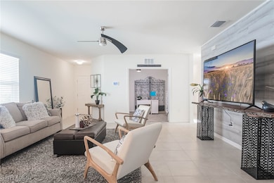 Living room with ceiling fan and light tile patter
