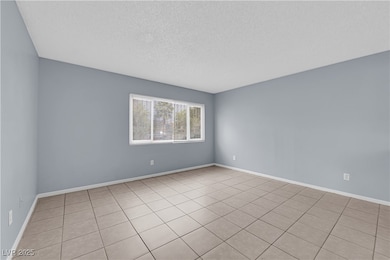 Spare room with baseboards and a textured ceiling