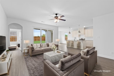 Living room with ceiling fan and dark wood-style flooring