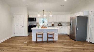 Kitchen with appliances, tile backsplash, solid surface counters, and USA-made cabinets