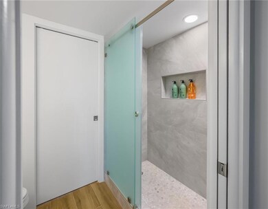 Full bathroom featuring tiled shower and wood fini