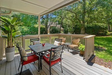 Wooden deck featuring outdoor dining space and view of wooded area