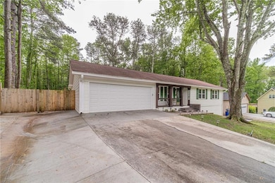 Ranch-style home featuring concrete driveway, an a