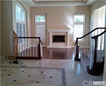 Step down to a huge living room with marble fire p