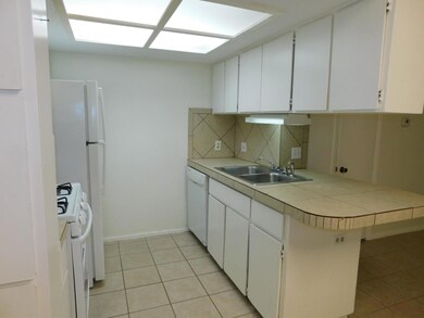 Kitchen with light tile patterned floors, white a