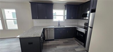 Kitchen with a peninsula, wood finished floors, a 