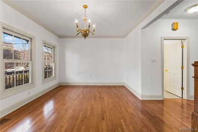 Empty room with a chandelier, ornamental molding, and light wood-type flooring