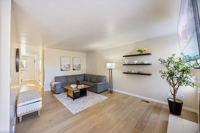 Living room featuring light wood-style floors and baseboards