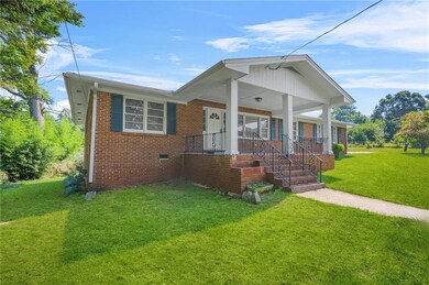 Bungalow-style house with a front lawn, brick siding, and a porch