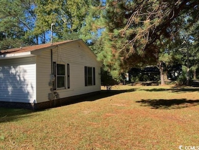 View of side of home featuring a lawn
