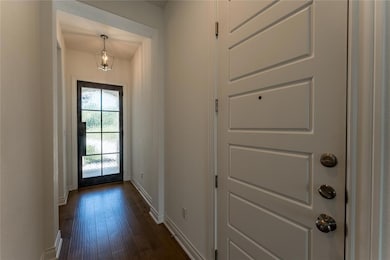 Entryway with baseboards and dark wood finished f