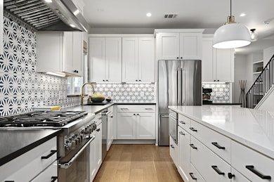 Kitchen featuring a sink, ventilation hood, light