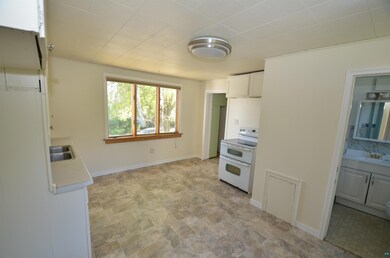 Kitchen featuring white cabinets, white electric s