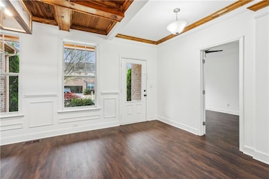 Foyer entrance featuring dark wood-style flooring, beamed ceiling, visible vents, and wood ceiling