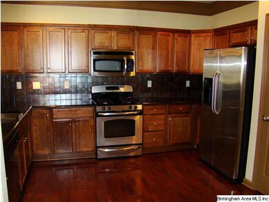 Kitchen has stainless appliances, gas stove, grani