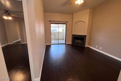 Unfurnished living room with a ceiling fan, dark w
