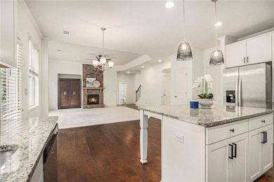 Kitchen with white cabinets, light stone counterto