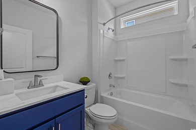 Bathroom with toilet, vanity, and  shower combination