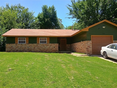 Ranch-style home with a garage, brick siding, and a front lawn