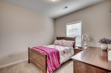 Bedroom featuring light carpet