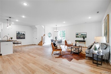 Living room featuring light hardwood / wood-style floors, sink, and a notable chandelier