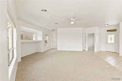 Unfurnished living room featuring ceiling fan, vis